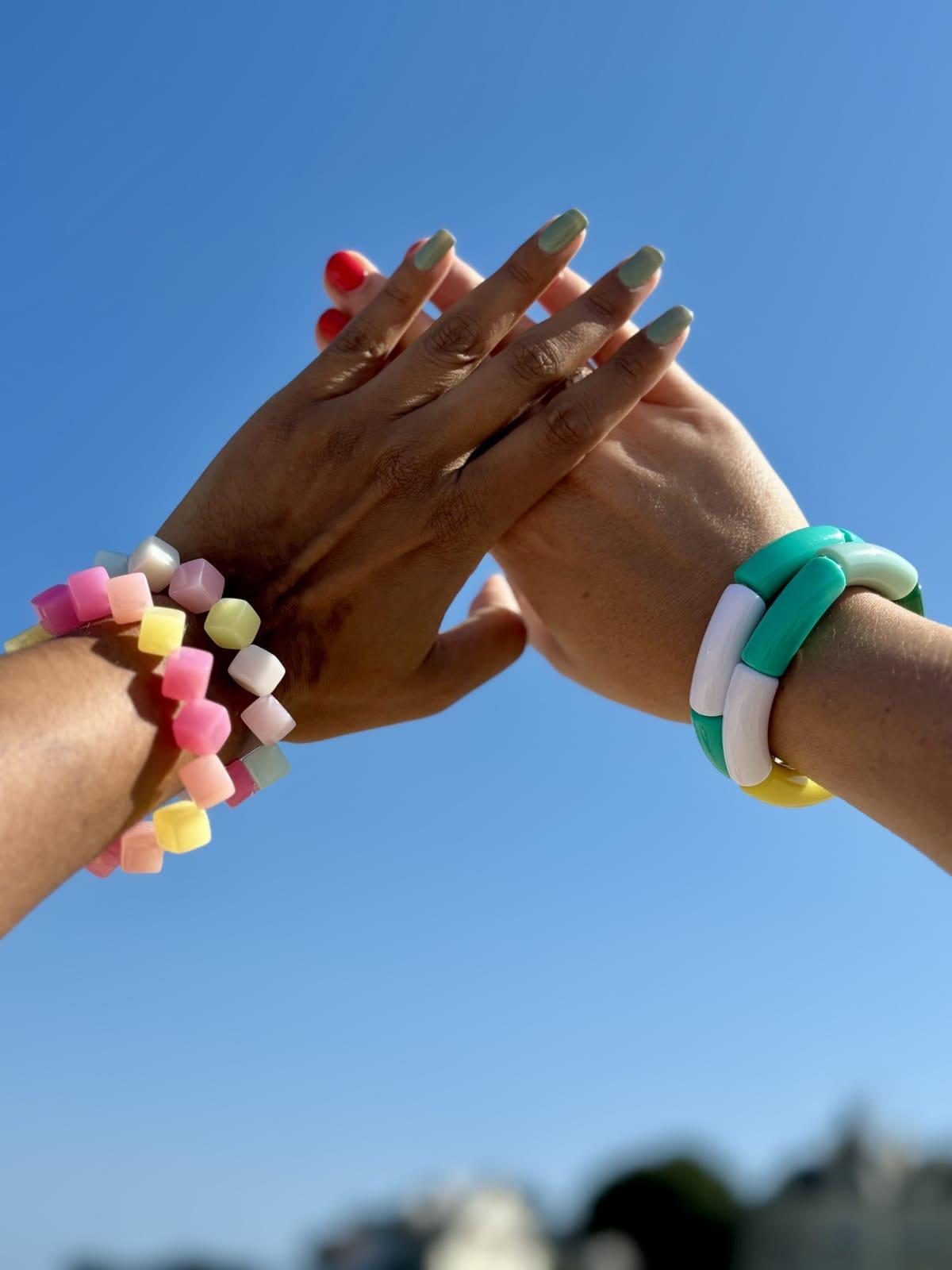 Bracelets en tubes acryliques colorés portés à la plage en été